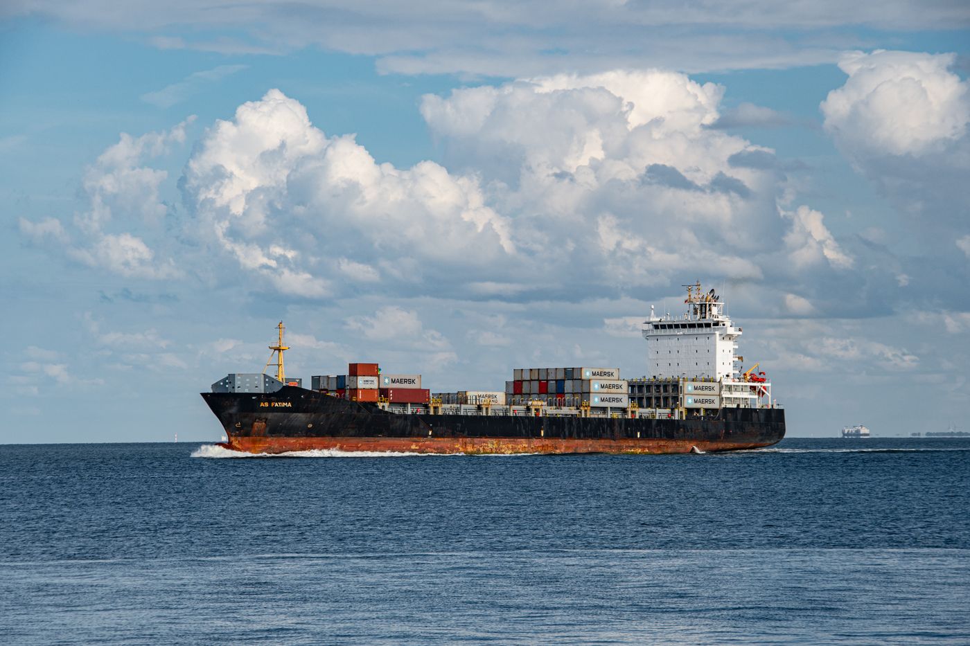 Container ship sailing on calm blue water