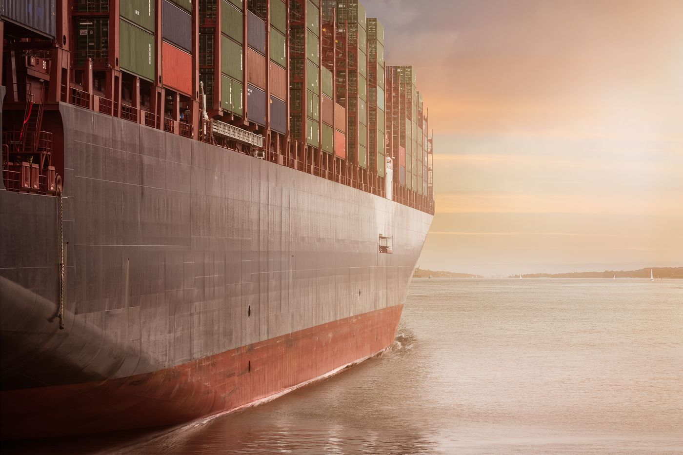 Colossal cargo ship sailing at sunset